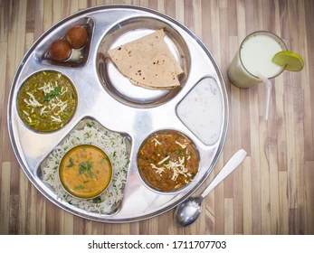 Traditional clay tandoor oven with breads stuck to sides and glowing embers visible at bottom